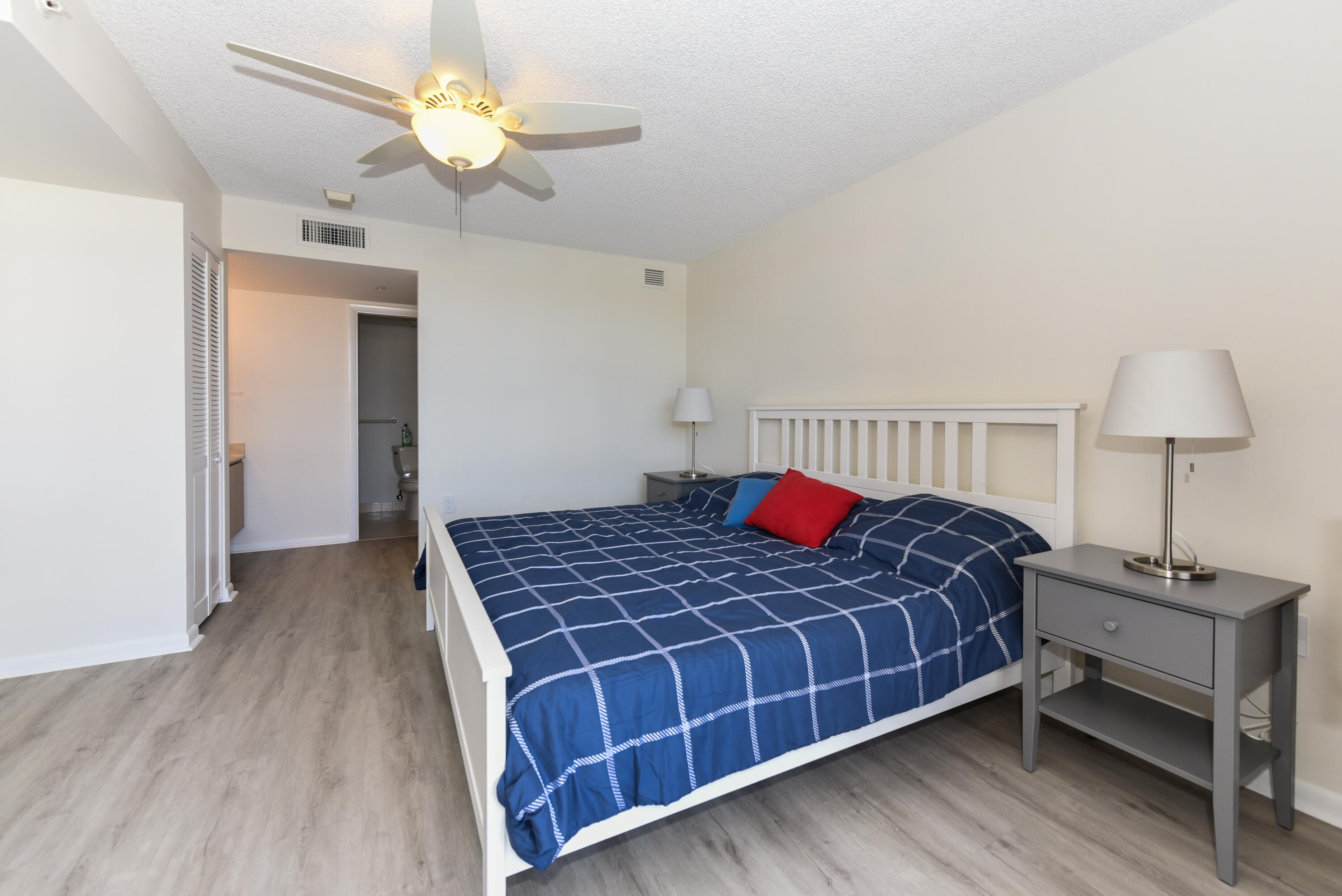 2401 Marina Isle Way, Unit 405 Jupiter, FL 33477 - Photo 24 of 30 a bedroom with a bed and a chandelier