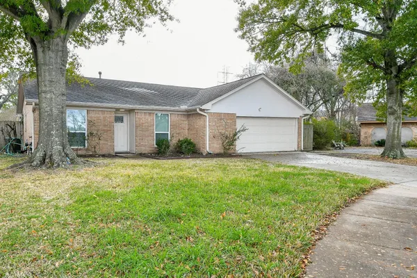 front view of a house with a yard and an trees