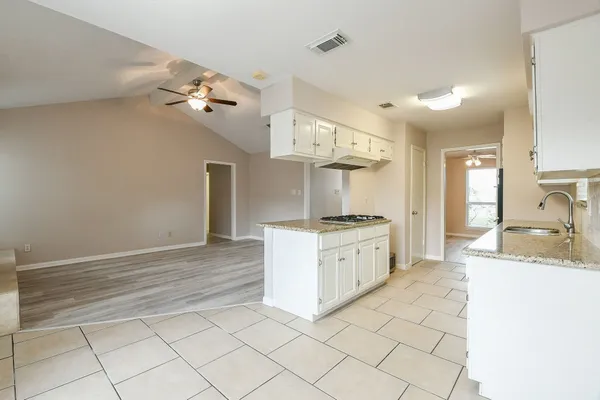 a kitchen with granite countertop white cabinets and white appliances