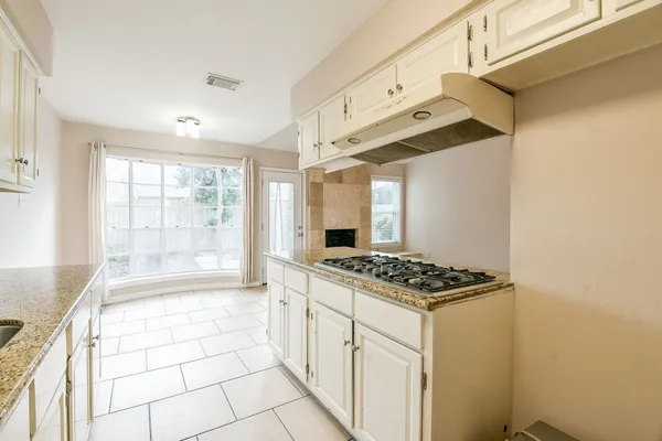 a kitchen with stainless steel appliances a sink a stove and cabinets