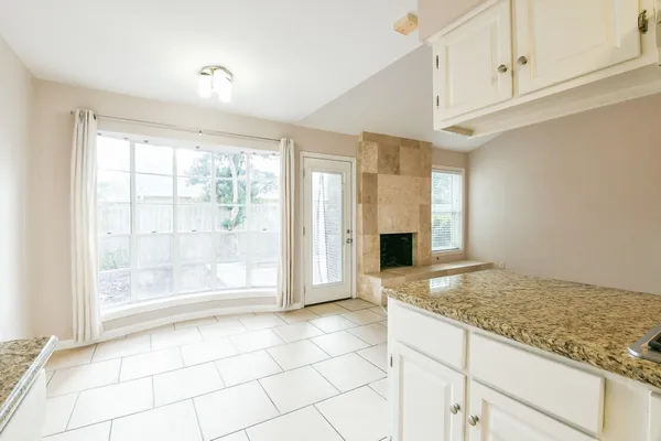 a view of an empty room with a fireplace and a window