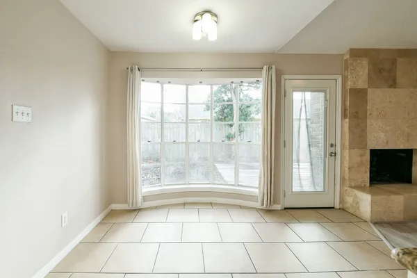 a view of an empty room with window and chandelier