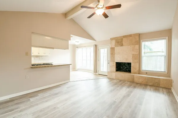 a view of an empty room with a fireplace and a window