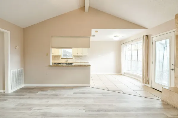 a view of a kitchen with wooden floor and a window