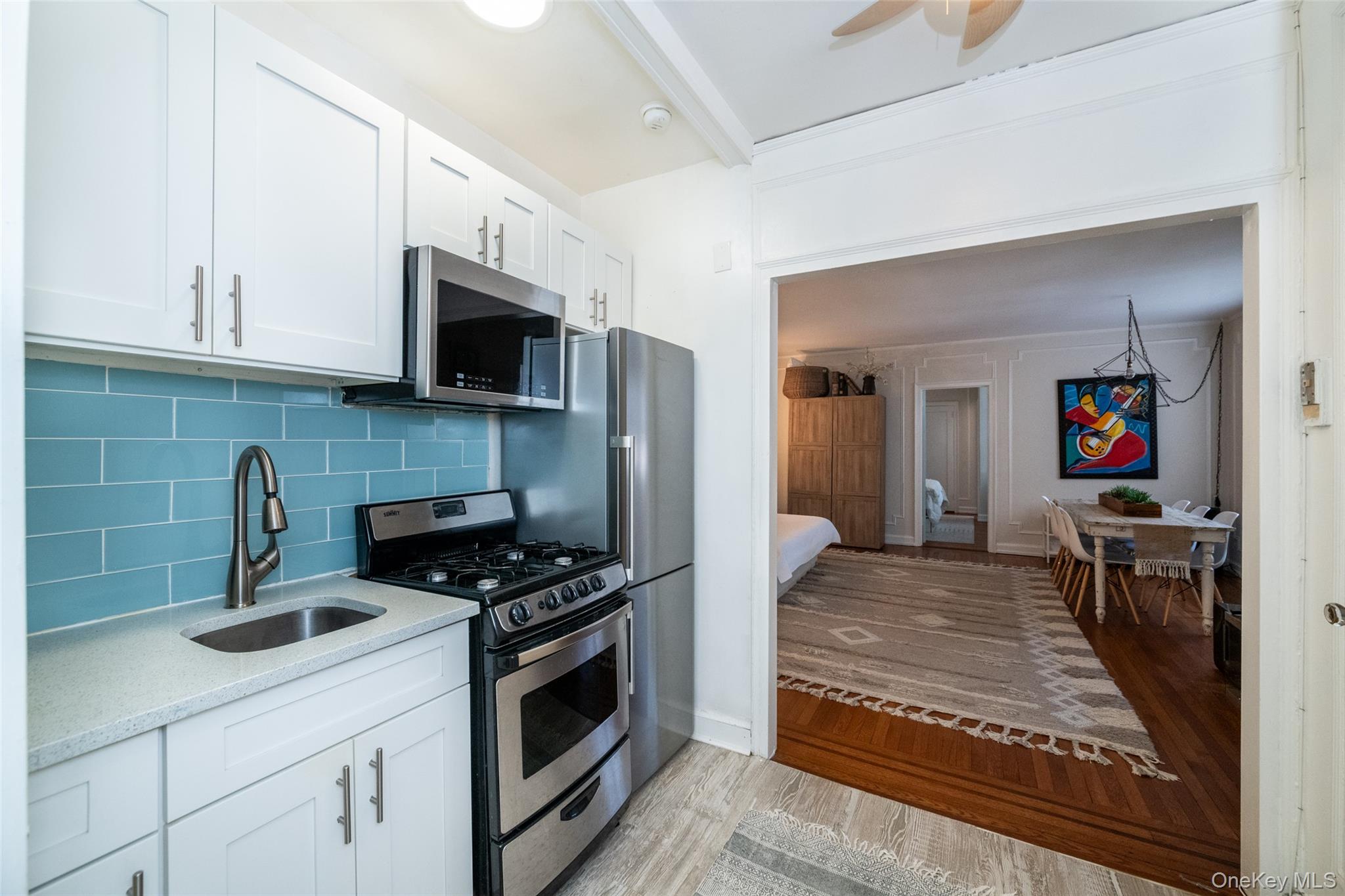 151 Centre Avenue, Unit 5B New Rochelle, NY 10805 - Photo 4 of 14 a kitchen with stainless steel appliances kitchen island granite countertop a stove a sink and a microwave