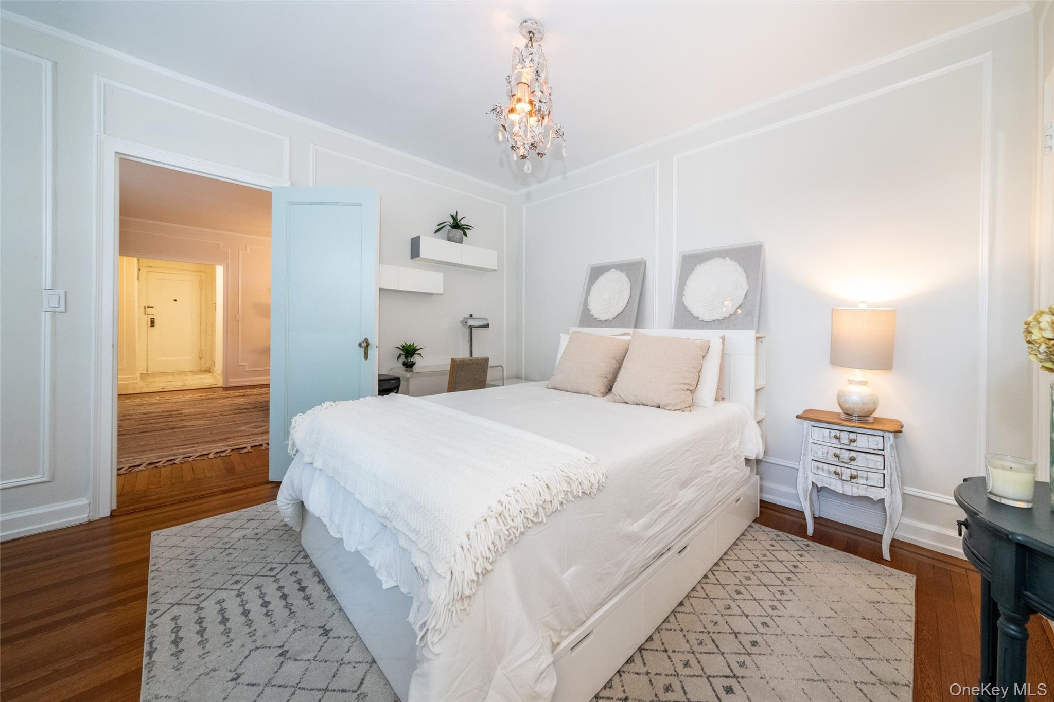 151 Centre Avenue, Unit 5B New Rochelle, NY 10805 - Photo 8 of 14 a bedroom with a bed and a chandelier