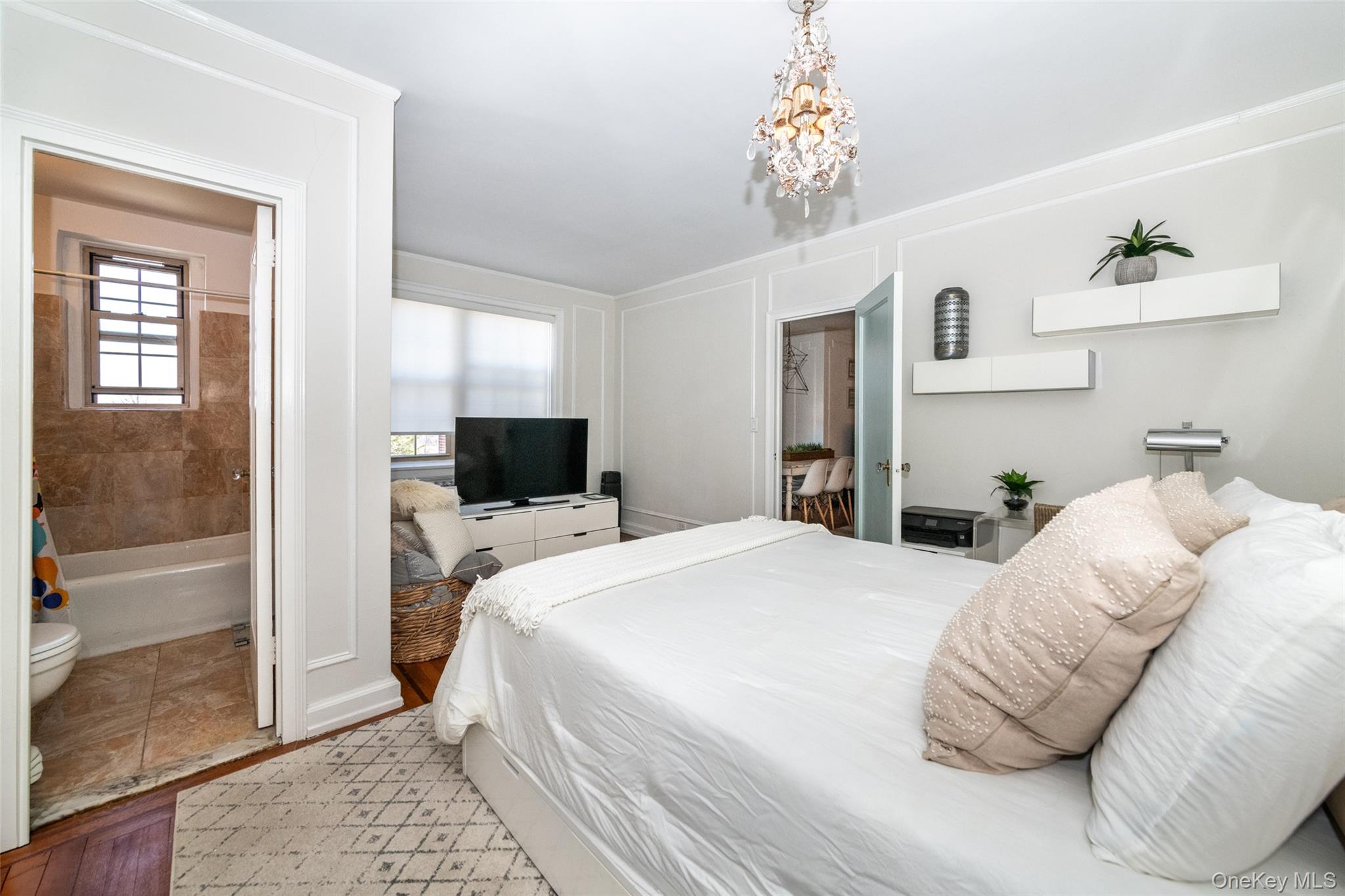 151 Centre Avenue, Unit 5B New Rochelle, NY 10805 - Photo 9 of 14 a bedroom with a bed and a chandelier