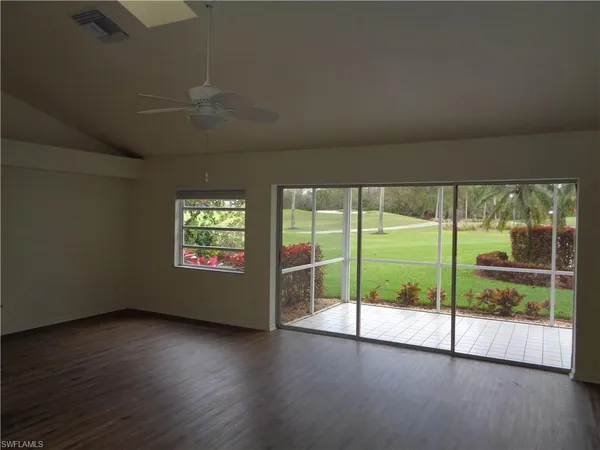 a view of an empty room with wooden floor and a floor to ceiling window