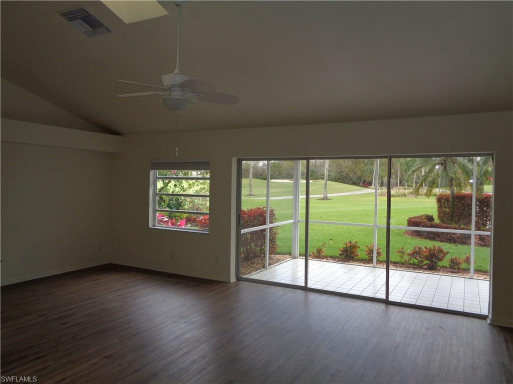 271 Perignon Place, Unit 161 Naples, FL 34119 - Photo 12 of 39 a view of an empty room with wooden floor and a floor to ceiling window
