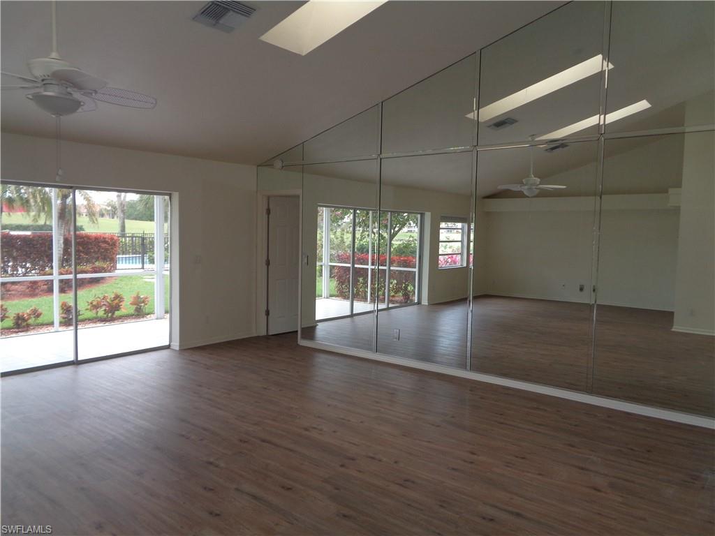 271 Perignon Place, Unit 161 Naples, FL 34119 - Photo 13 of 39 an empty room with wooden floor and windows