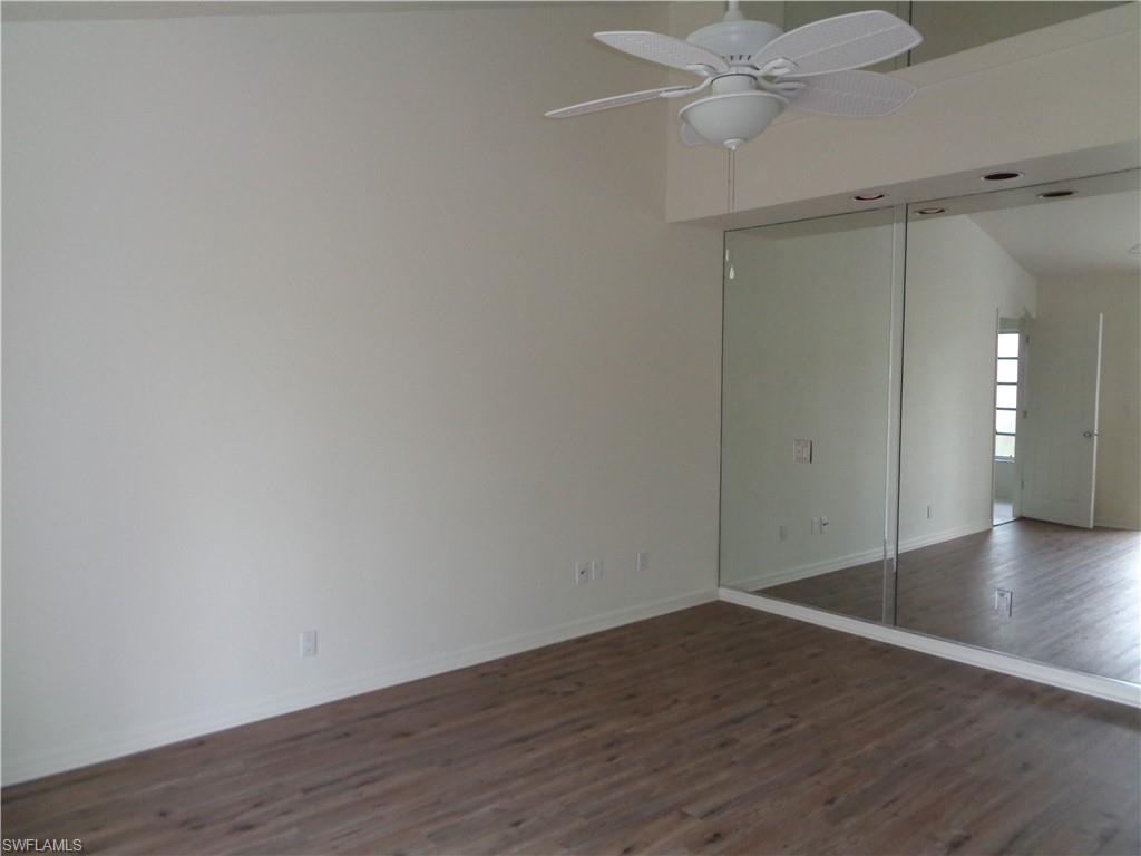 271 Perignon Place, Unit 161 Naples, FL 34119 - Photo 15 of 39 a view of an empty room with wooden floor and a ceiling fan