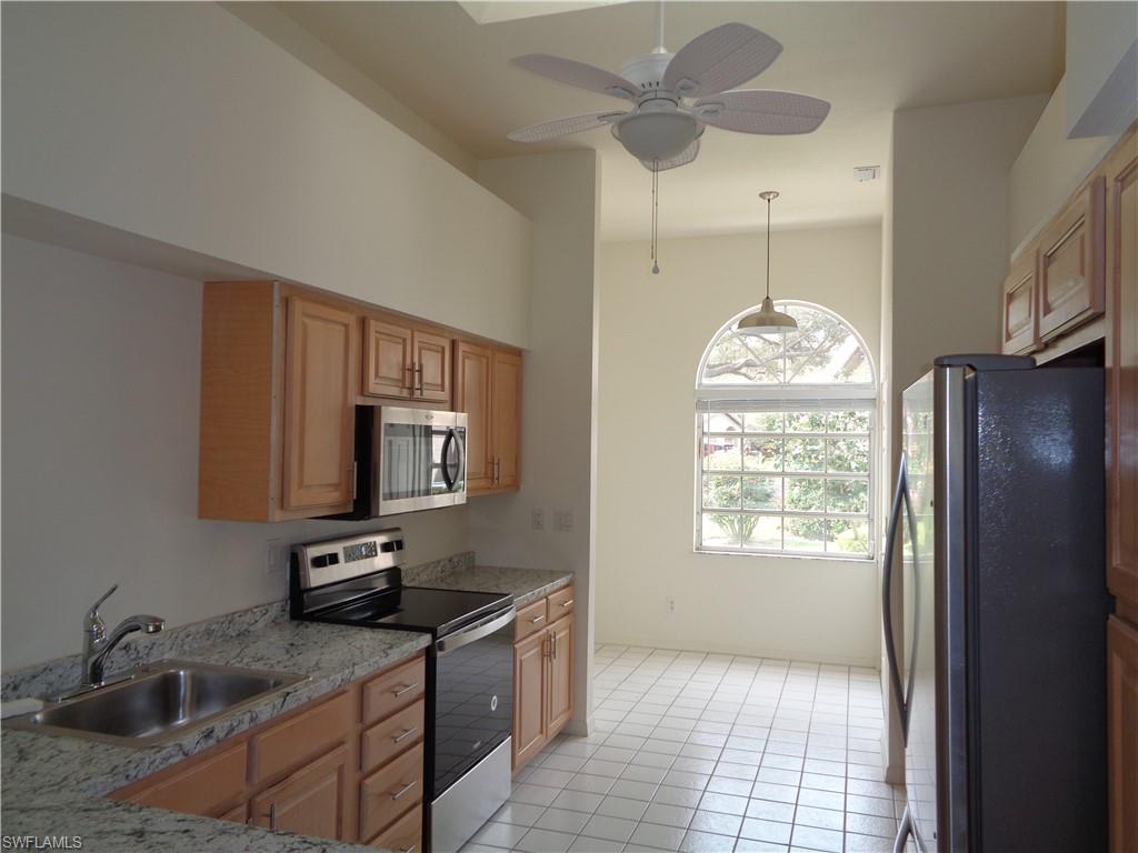 271 Perignon Place, Unit 161 Naples, FL 34119 - Photo 18 of 39 a kitchen with stainless steel appliances granite countertop a sink refrigerator and microwave