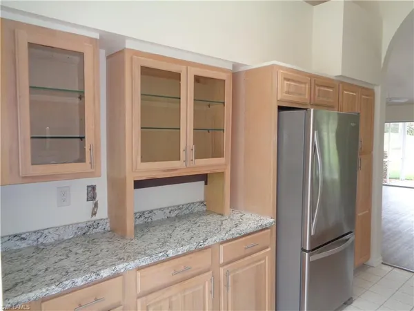 a kitchen with granite countertop a refrigerator and a sink
