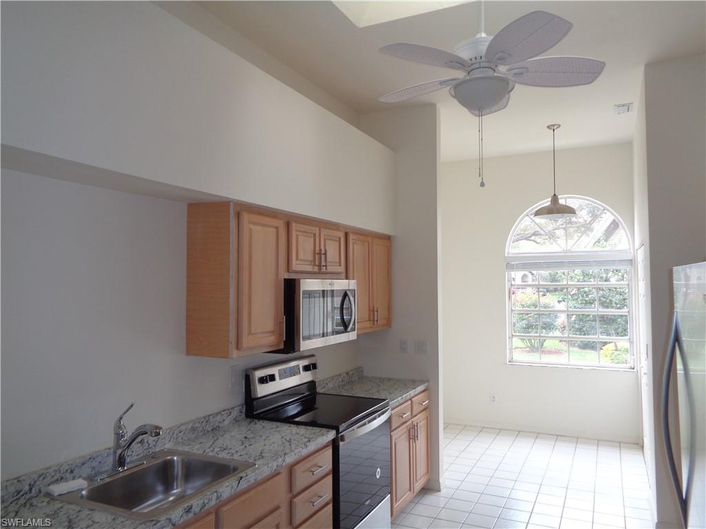 271 Perignon Place, Unit 161 Naples, FL 34119 - Photo 23 of 39 a kitchen with stainless steel appliances granite countertop a sink and a microwave