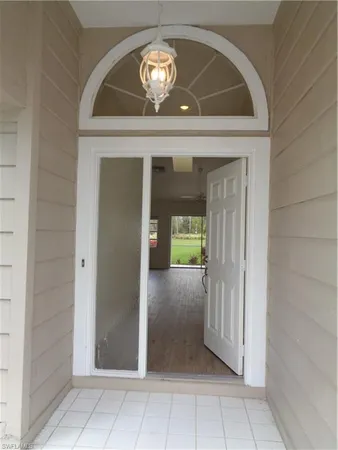 a view of a hallway with wooden floor and a mirror