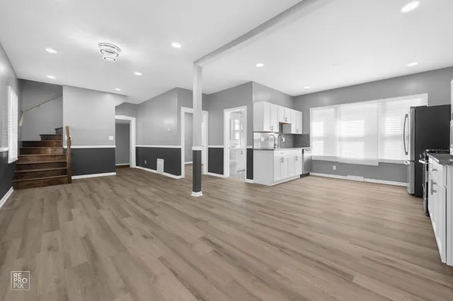 a view of a kitchen with refrigerator microwave and wooden floor