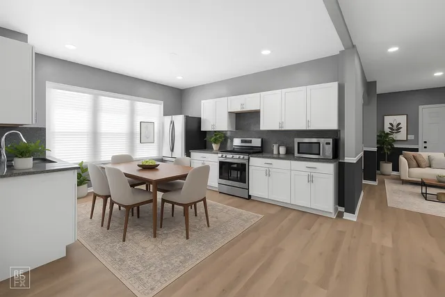 a living room with stainless steel appliances granite countertop furniture wooden floor and a kitchen view
