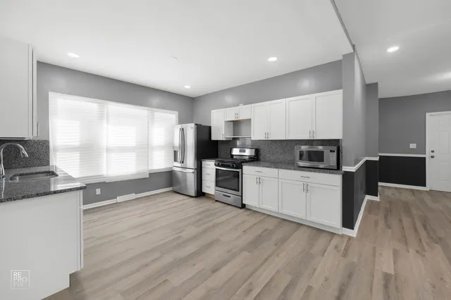 a kitchen with stainless steel appliances granite countertop a stove a sink and a refrigerator