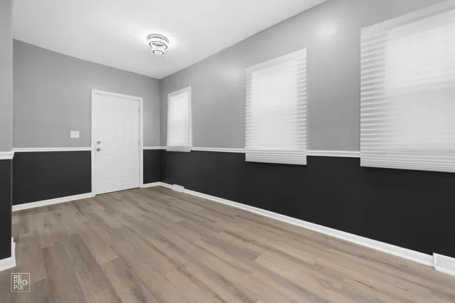 a view of a big room with wooden floor and windows