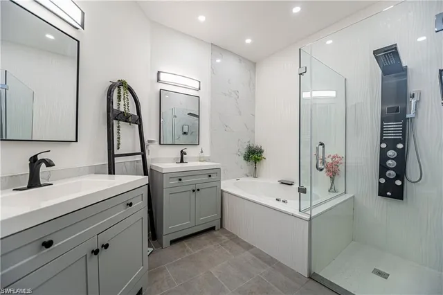 a bathroom with a double vanity sink mirror and shower