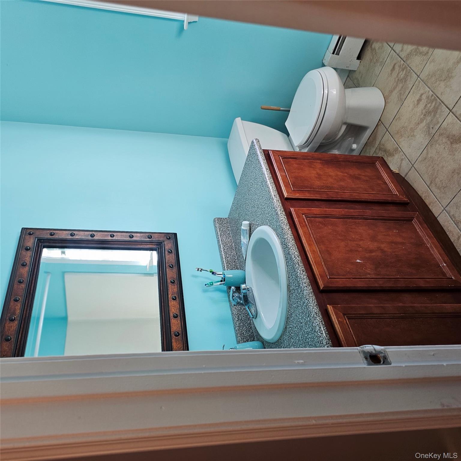 235 Maples Road Middletown, NY 10940 - Photo 20 of 34 Bathroom with vanity, light tile patterned floors, and a baseboard heating unit