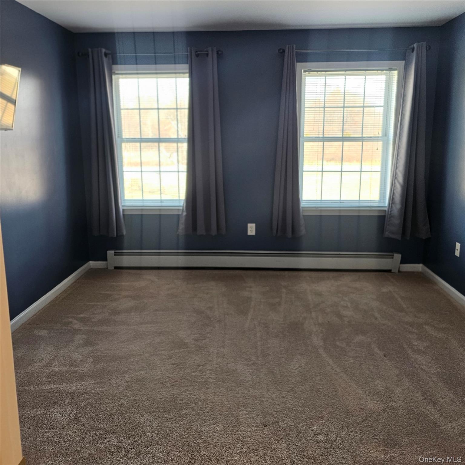 235 Maples Road Middletown, NY 10940 - Photo 23 of 34 Spare room with healthy amount of natural light, dark colored carpet, and a baseboard heating unit