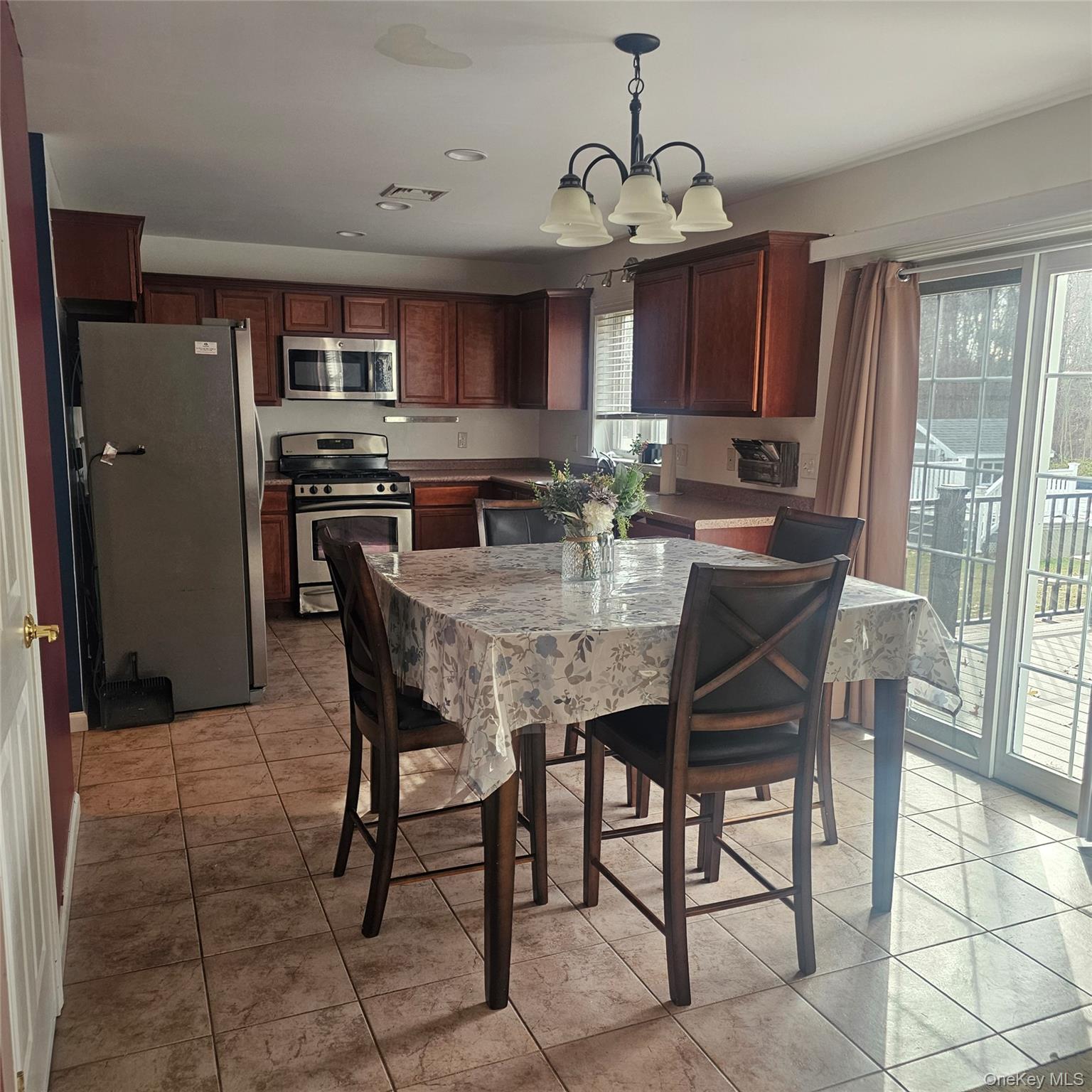235 Maples Road Middletown, NY 10940 - Photo 10 of 34 Kitchen with hanging light fixtures, appliances with stainless steel finishes, light tile patterned floors, and a chandelier