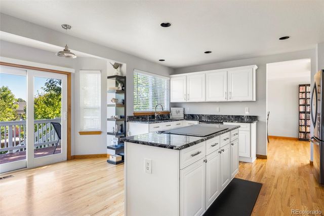 a kitchen with a stove window and wooden floor