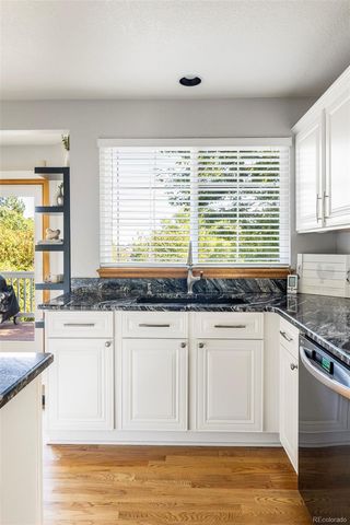 a kitchen with granite countertop a sink a stove and cabinets
