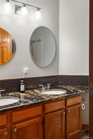 a bathroom with a granite countertop sink a mirror and vanity