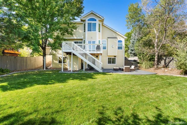 a view of a house with a big yard and large trees