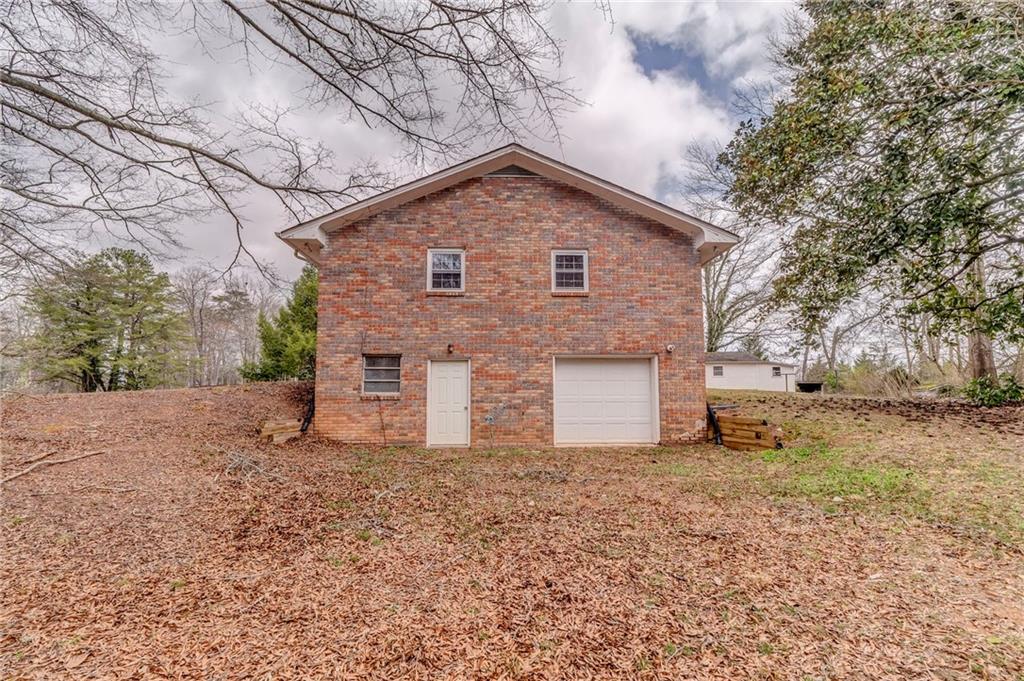 1065 Cartersville Street Ball Ground, GA 30107 - Photo 15 of 51 a front view of house with yard and trees around