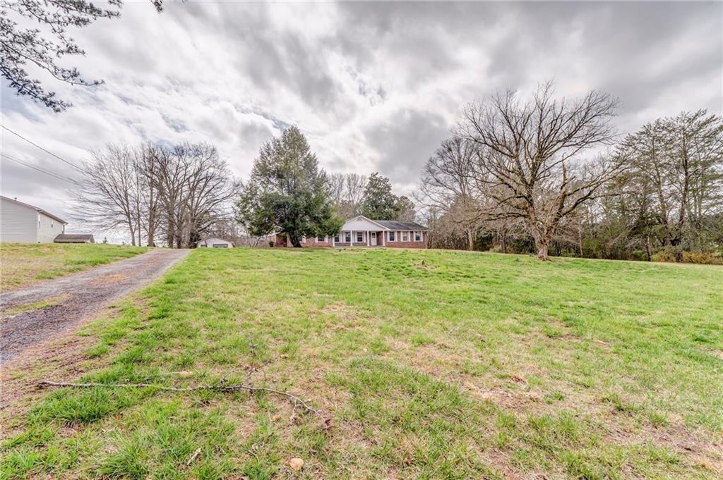 1065 Cartersville Street Ball Ground, GA 30107 - Photo 19 of 51 a view of a field with large trees