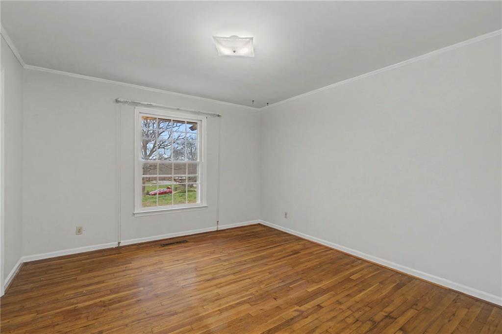 1065 Cartersville Street Ball Ground, GA 30107 - Photo 27 of 51 wooden floor in an empty room with a window