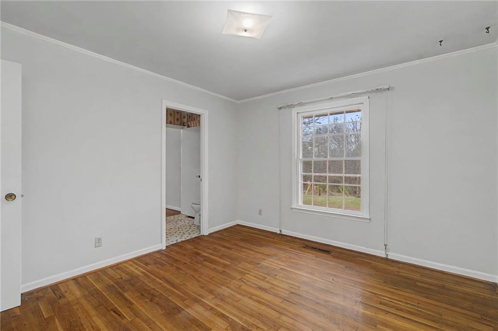 1065 Cartersville Street Ball Ground, GA 30107 - Photo 28 of 51 an empty room with wooden floor and a window