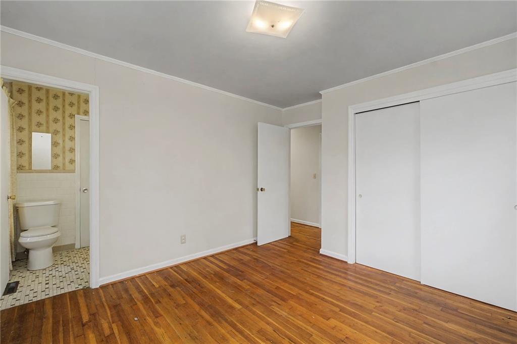 1065 Cartersville Street Ball Ground, GA 30107 - Photo 32 of 51 a view of a room with wooden floor and toilet