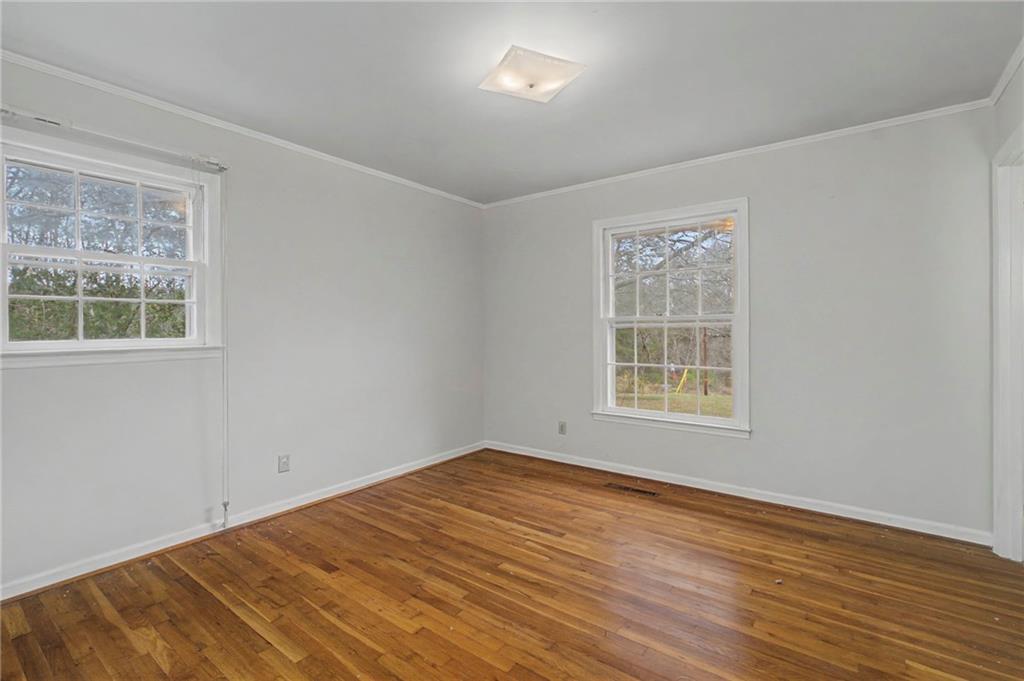 1065 Cartersville Street Ball Ground, GA 30107 - Photo 33 of 51 a view of an empty room with wooden floor and a window