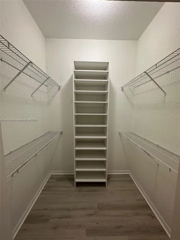 a view of walk in closet with empty racks