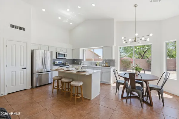 a kitchen with kitchen island a table and chairs in it