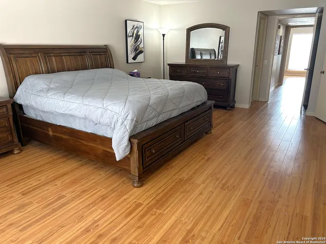 a bedroom with a bed and wooden floor