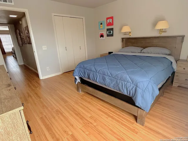 a bedroom with a bed and wooden floor
