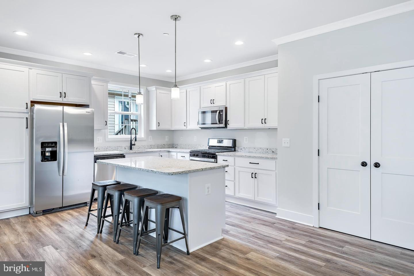 404 Paradise Road Riva, MD 21140 - Photo 8 of 51 a kitchen with stainless steel appliances granite countertop a refrigerator a sink dishwasher a stove and white cabinets with wooden floor