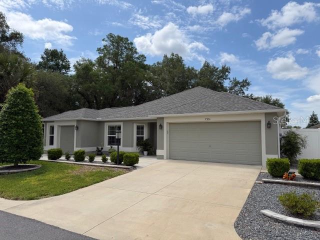 7351 Southeast 169th Cote Loop The Villages, FL 32162 - Photo 1 of 32 front view of a house with a garden