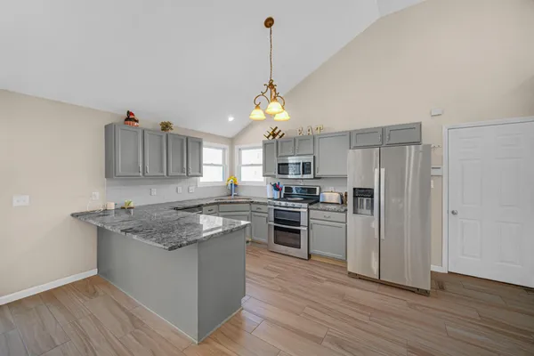 a kitchen with kitchen island granite countertop a sink cabinets and stainless steel appliances
