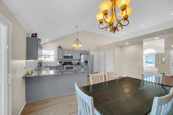 a kitchen with a table chairs and living room view