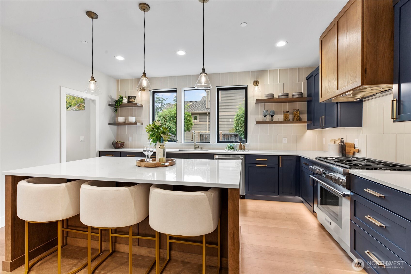1504 3rd Street Kirkland, WA 98033 - Photo 9 of 36 a kitchen with stainless steel appliances granite countertop a stove a sink a oven a dining table and chairs with wooden floor