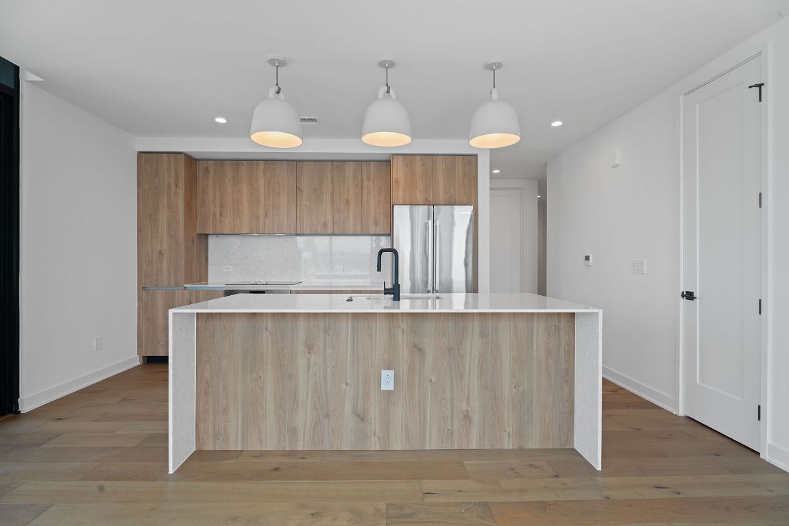 84 East Avenue, Unit 3401 Austin, TX 78701 - Photo 11 of 40 a kitchen with kitchen island a sink stainless steel appliances and cabinets