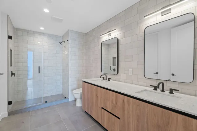 a bathroom with double sink and a mirror