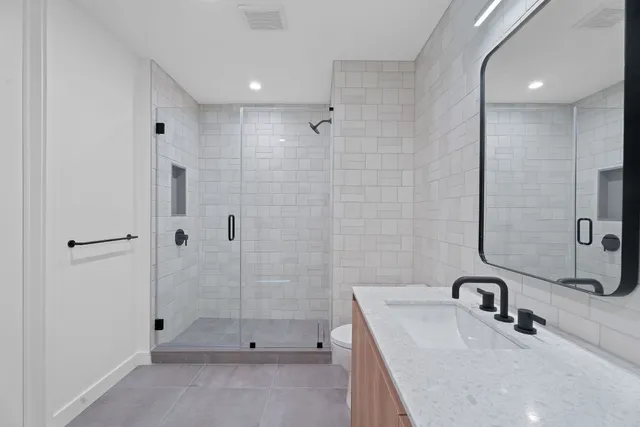 a bathroom with a sink a toilet and shower