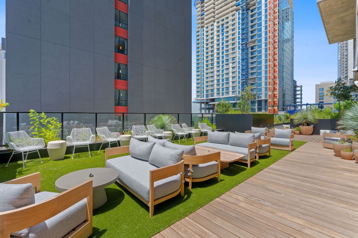 84 East Avenue, Unit 3401 Austin, TX 78701 - Photo 32 of 40 a living room with patio furniture and a garden